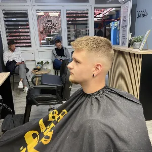 Stranka sjedi u frizerskom salonu i gleda se u ogledalo