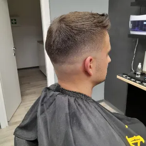 Mlađi muškarac slikan iz profila nakon nove fade frizure
